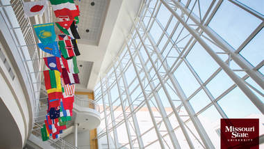 Zoom background: Strong Hall atrium with flags.
